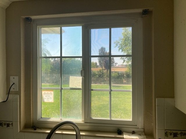 A kitchen window with nothing between it and July.