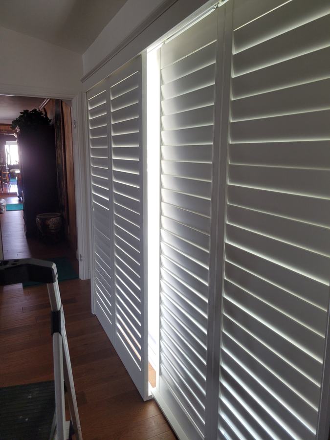 Sliding shutter panels across a patio door