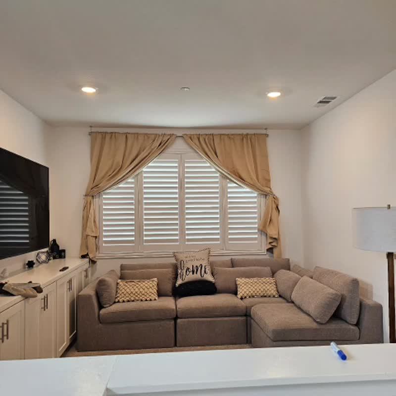Living room shutters behind full length drapery