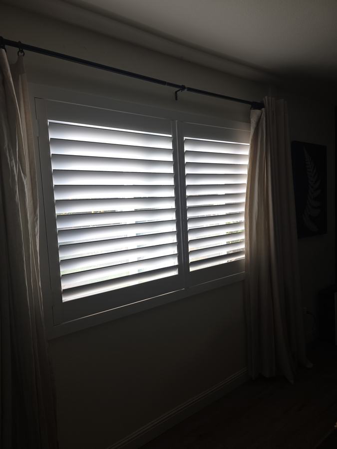 Shutters behind sheer drapes