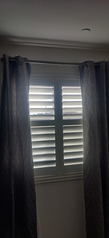 Shutters behind gray curtains
