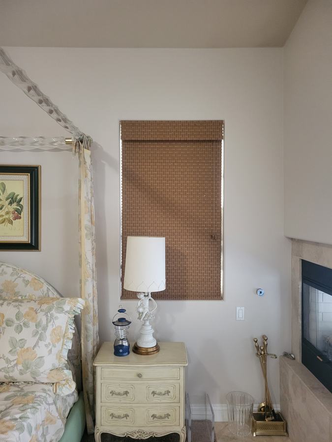A woven shade in a bedroom